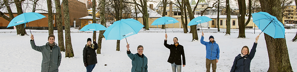 Sex personer på VA-guiden står i snön och håller upp blåa VA-guiden paraplyer