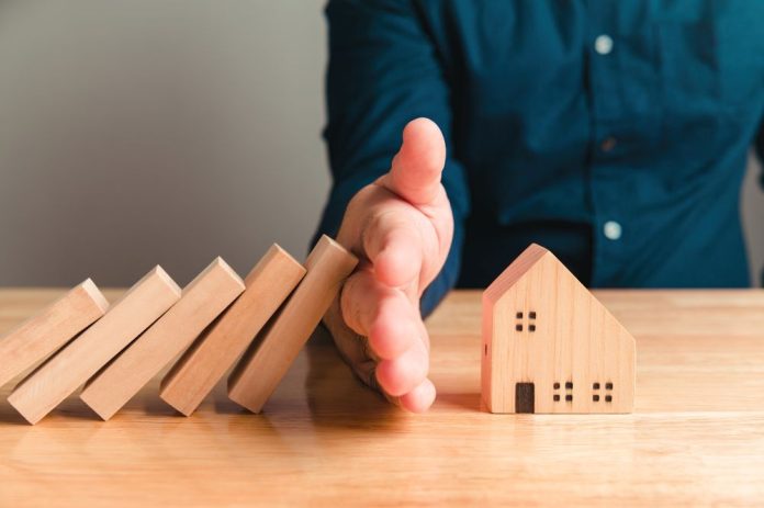 Arm skyddar hus mot dominobrickor