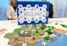 blå spelkartong bakom ett brädspel på ett bord