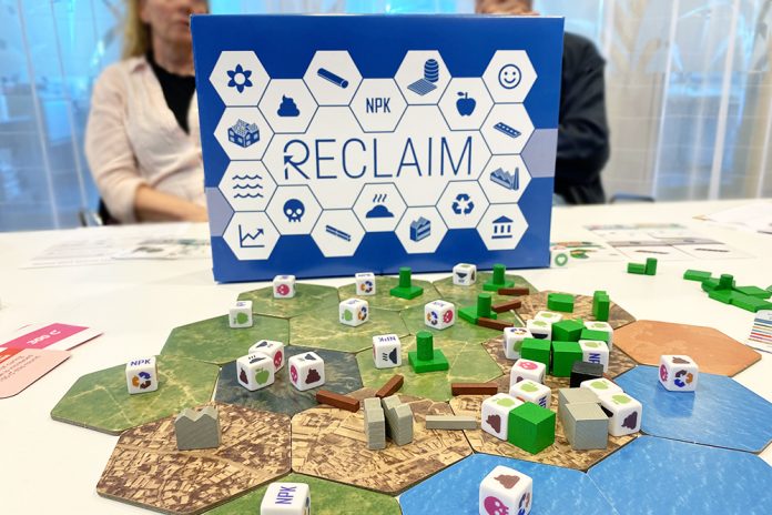 blå spelkartong bakom ett brädspel på ett bord