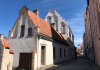 Vitt hus med trappstegsgavel. Gatuvy från Visby innanför ringmuren.