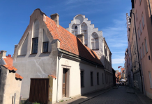 Vitt hus med trappstegsgavel. Gatuvy från Visby innanför ringmuren.
