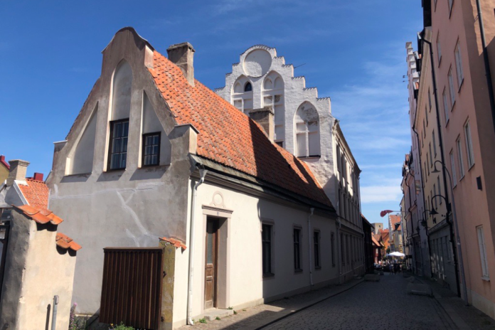 Vitt hus med trappstegsgavel. Gatuvy från Visby innanför ringmuren.